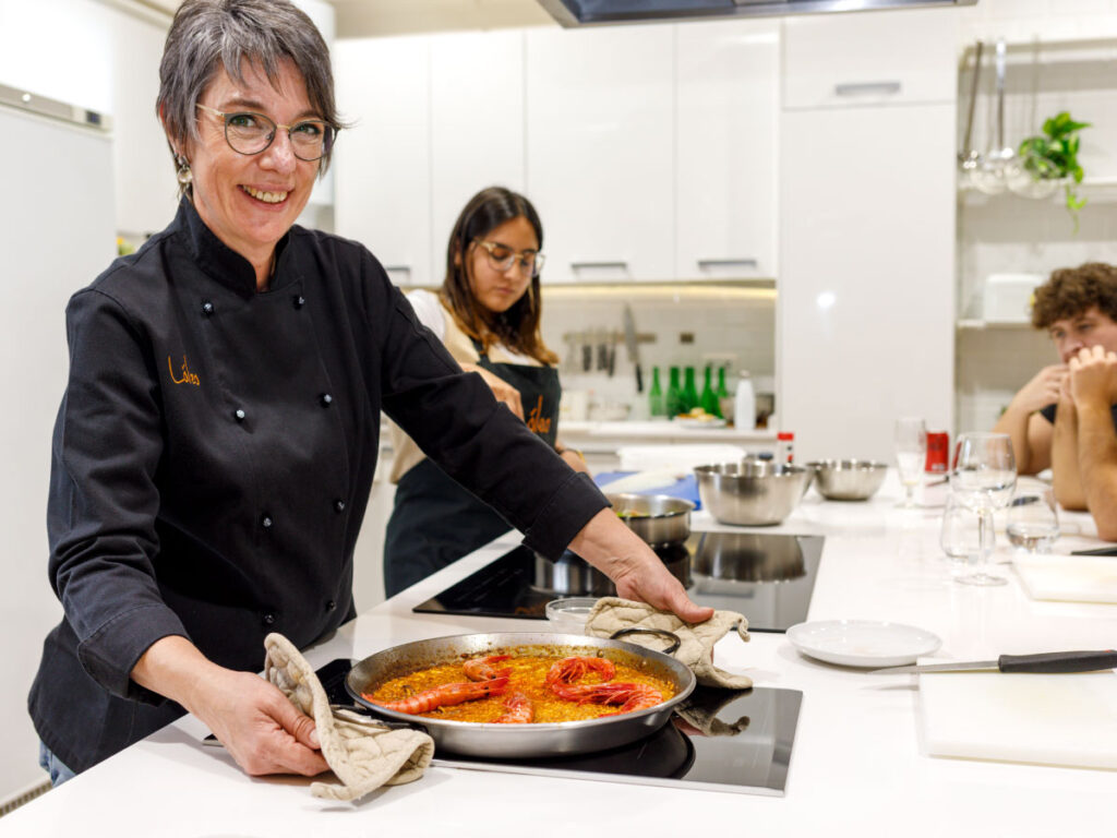Nuestra chef Lola, una apasionada de la gastronomía española impartiendo clases de cocina en Madrid a un grupo de turistas en una de las mejores escuelas de cocina de la capital.