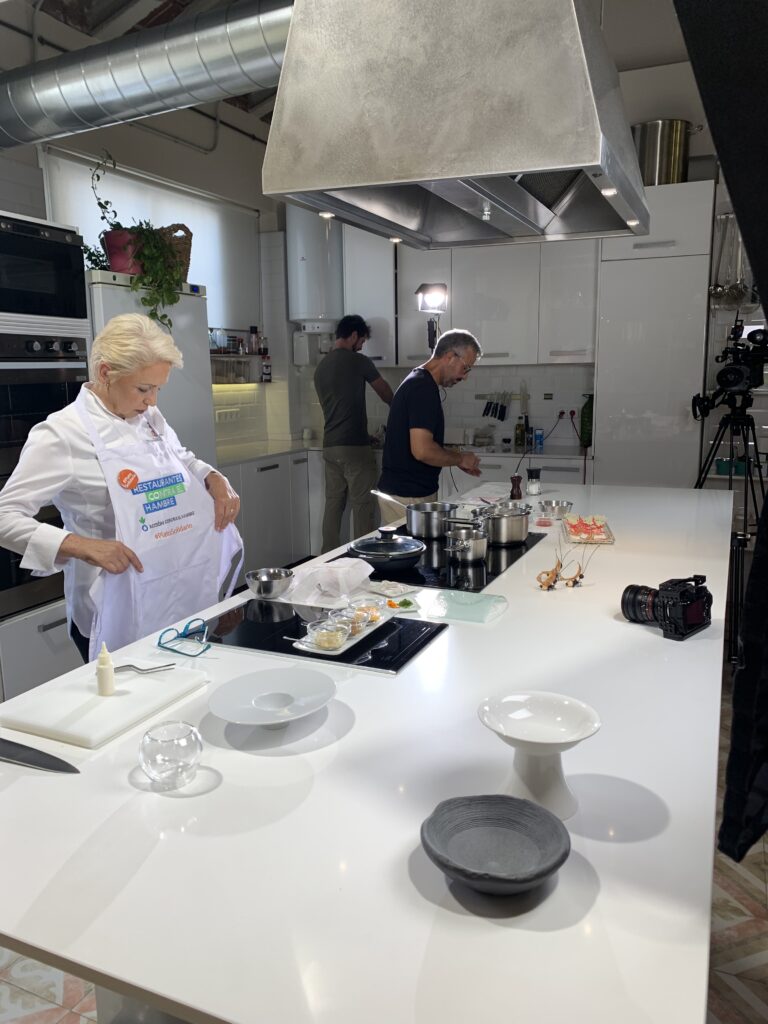 Equipo audiovisual grabando campaña de acción contra el hambre en las cocinas de Lóleo como escenario de fondo