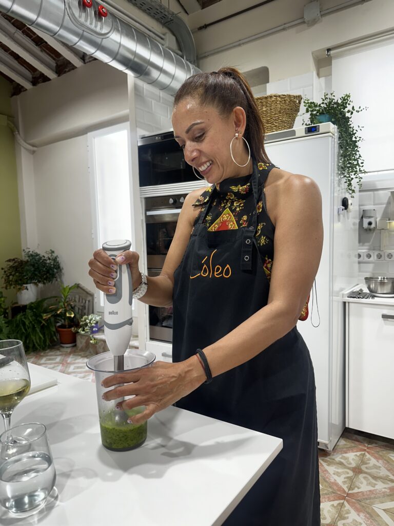 Mujer preparando bacalao ajoarriero, una de las tapas tradicionales enseñadas en nuestras clases de cocina en Madrid.