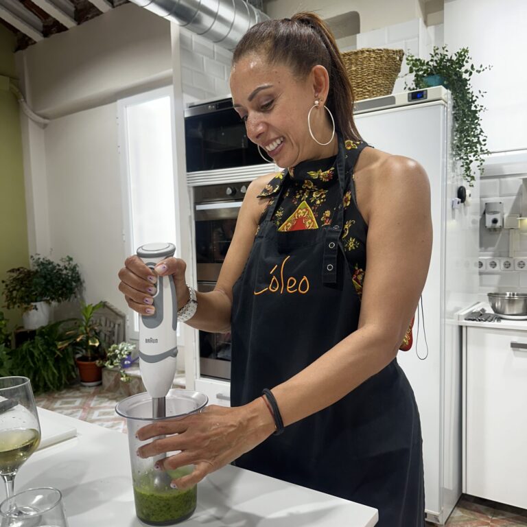 Mujer preparando bacalao ajoarriero, una de las tapas tradicionales enseñadas en nuestras clases de cocina en Madrid.