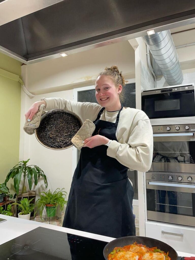 Turista orgullosa mostrando la paella perfecta que preparó durante las clases de cocina en Madrid con Lóleo