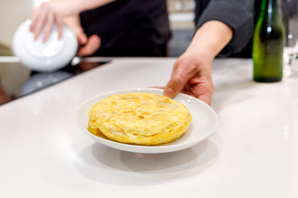 Lola mostrando uan de las tapas de tortilla que prepara en su curso de cocina en Madrid.